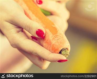 Woman peeling vegetables using food peeler. Cooking female preparing carrot before serving.. Woman peeling carrot vegetable