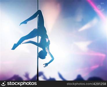 Woman performs sensual, passionate pole dance in night club. Sexy body silhouette, professional, sexual pose.