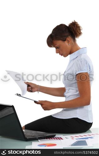 Woman perusing documents at her desk