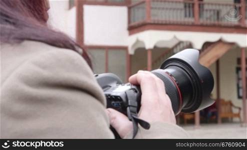 Woman photographer takes pictures in the city
