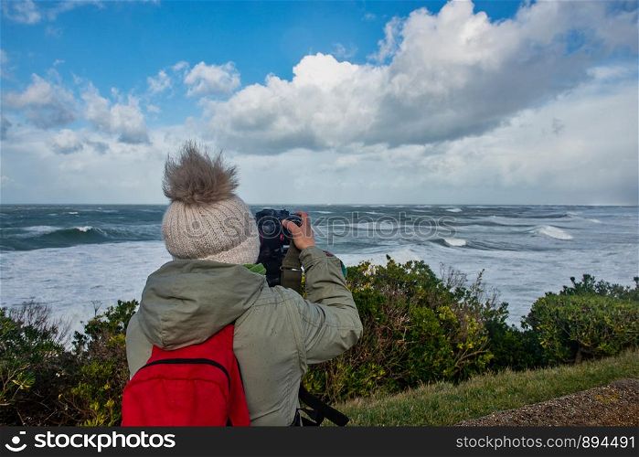 woman photographer working during a storm in Biarritz France