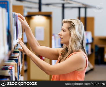 Woman picking a book in public library. That is a difficult choice