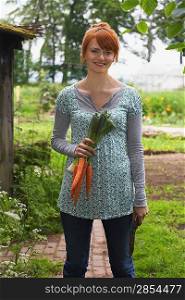 Woman Picking Carrots in Garden