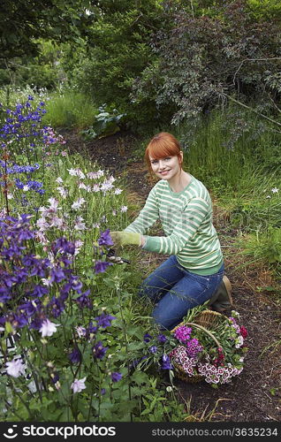 Woman picking flowers in garden, portrait