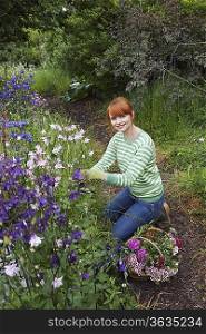 Woman picking flowers in garden, portrait