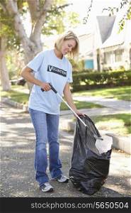 Woman Picking Up Litter In Suburban Street