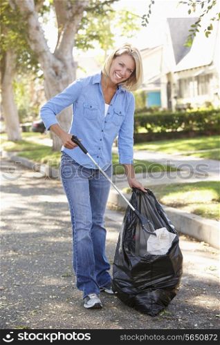 Woman Picking Up Litter In Suburban Street