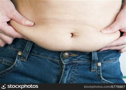 Woman pinching fat from her abdomen. Close up shot&#xA;