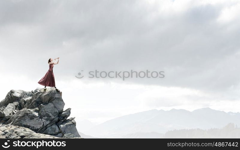 Woman play fife. Young woman in evening dress playing fife