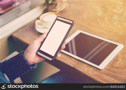 Woman play smartphone and drink coffee with vintage tone.