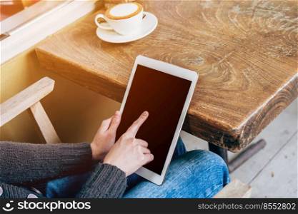 woman play tablet computer in coffee shop with vintage toned.