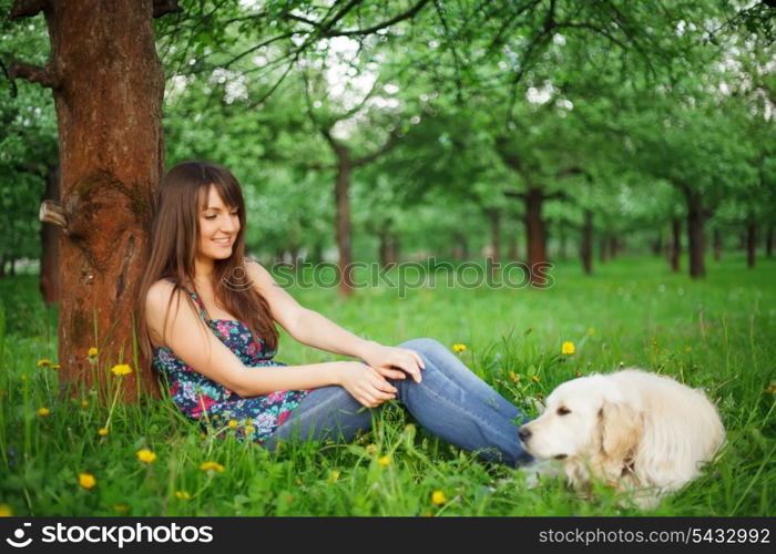 Woman play with her dog - golden retriever in the park