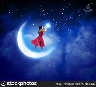 Woman playing flute. Young woman in red dress standing on moon and playing fife