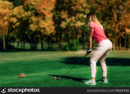 Woman playing golf, getting ready for the shot