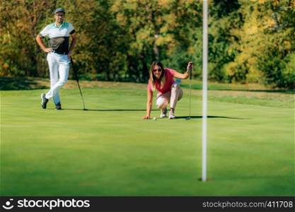Woman playing golf, reading the green