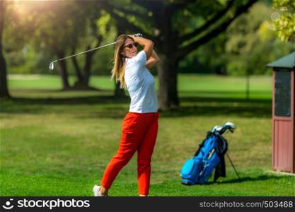Woman playing golf. Young female golfer on the tee box