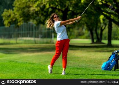 Woman playing golf. Young female golfer on the tee box