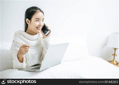Woman playing laptop and talking on the phone.