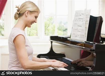 Woman playing piano and smiling