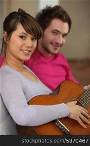 Woman playing the guitar for her boyfriend