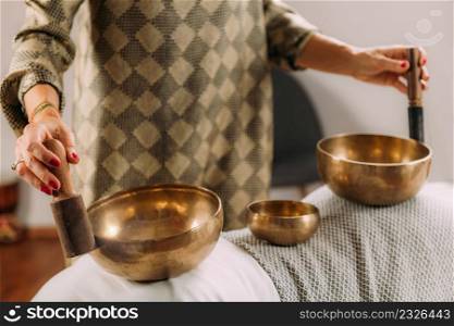 Woman playing Tibetan singing bowl in sound healing therapy . Tibetan Singing Bowl in Sound Therapy