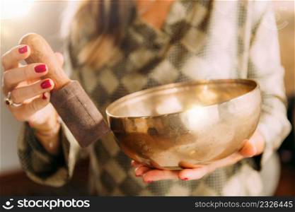Woman playing Tibetan singing bowl in sound healing therapy . Tibetan Singing Bowl in Sound Therapy