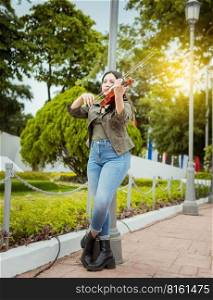 Woman playing violin in the street. Portrait of violinist girl playing in the street. Woman artist playing violin outdoors, Girl lying down playing violin in a park