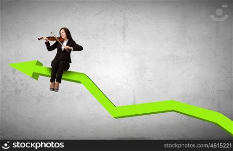 Woman playing violin. Young businesswoman sitting on increasing graph and playing violin