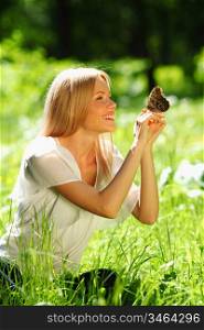 Woman playing with a butterfly on green grass
