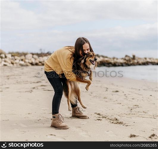 woman playing with dog beach