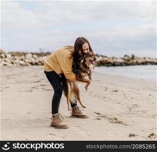 woman playing with dog beach