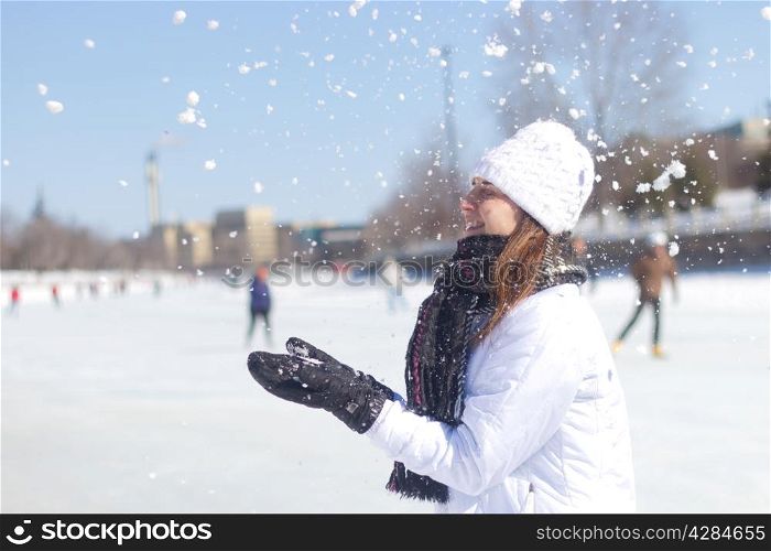 Woman playing with snowflakes during winter