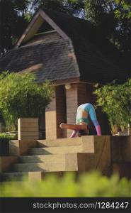 woman playing yoga outdoor of home terrace