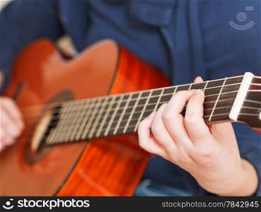 woman plays on classical acoustic guitar close up