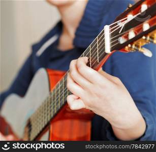 woman plays on modern acoustic guitar close up