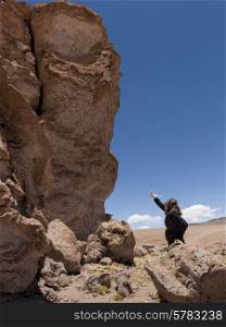 Woman pointing at Pakana Monk, Salar de Atacama, San Pedro de Atacama, El Loa Province, Antofagasta Region, Chile