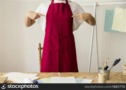 woman pointing her red apron. Resolution and high quality beautiful photo. woman pointing her red apron. High quality and resolution beautiful photo concept