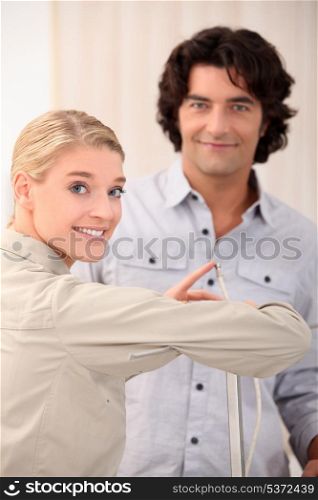 Woman pointing the end of a cable out to a man