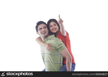 Woman pointing while getting a piggyback ride