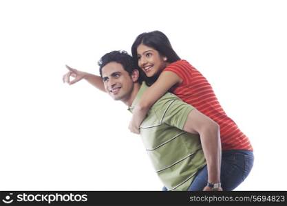 Woman pointing while getting a piggyback ride