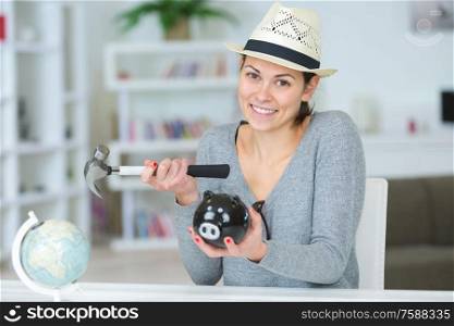 woman poised to smash piggy bank with hammer