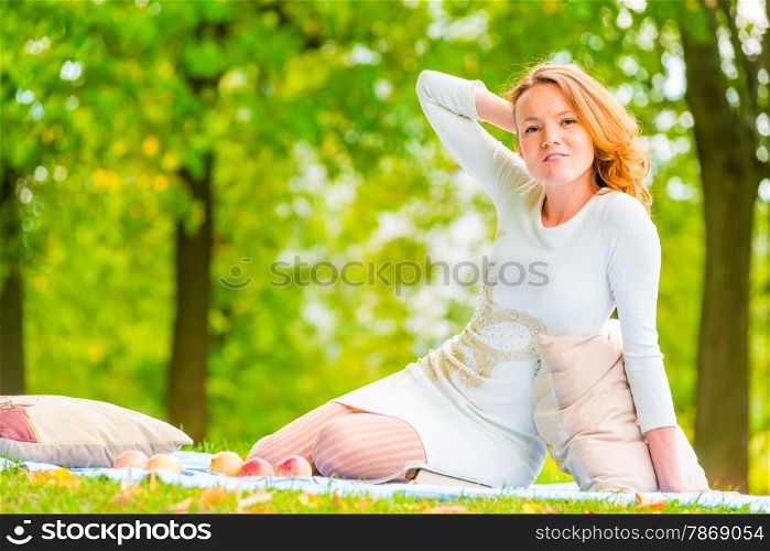 woman posing in an empty summer park on the lawn