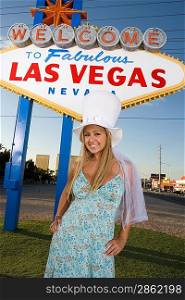 Woman posing in front of Las Vegas welcome sign, Nevada, USA