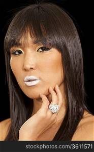Woman posing on black background wearing beautiful ring with white lipstick