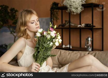 woman posing sofa while holding bouquet delicate spring flowers