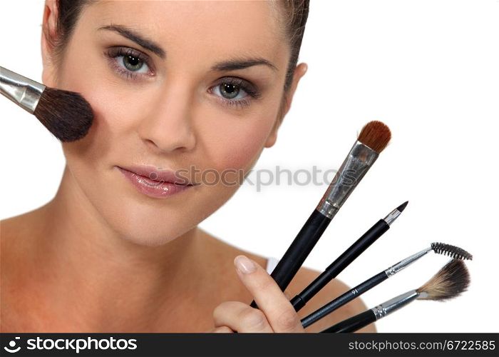 Woman posing with her make-up brushes