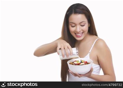 Woman pouring milk into a bowl of cereal