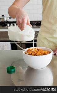 Woman pouring milk onto cereal