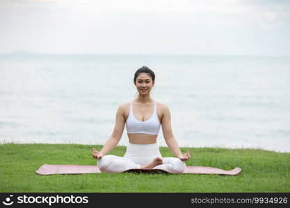 woman practice yoga lotus pose to meditation with summer vacation on the beach feeling so happiness and cheerful,Travel in tropical beach in Thailand,vacations and relaxation Concept