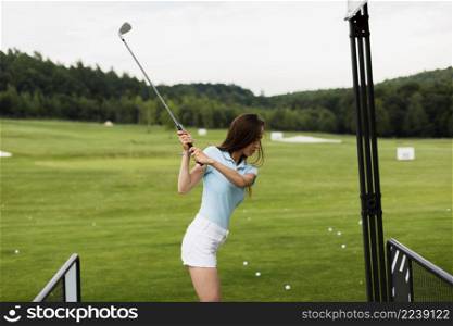 woman practicing golf swing outside